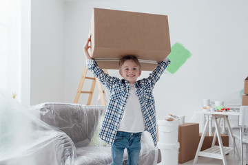 Boy carrying a big box - obrazy, fototapety, plakaty