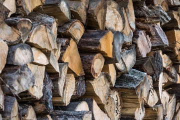 Chopped firewood, stacked woodfuel, fuelwood texture. Natural wooden background.