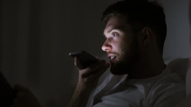 man with smartphone using voice recorder at night