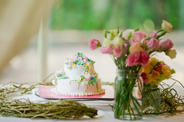 Wedding cake decorated with roses on table