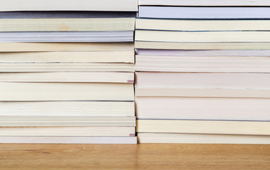 Books stacked on a wooden table.