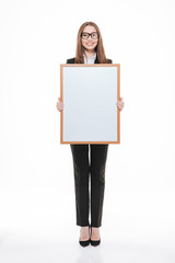 Smiling young businesswoman holding blank board