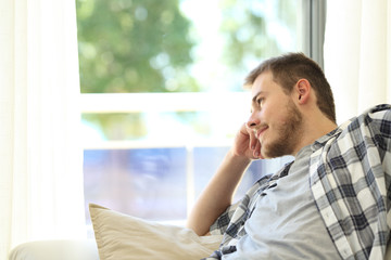 Man sitting on a couch and looking through a window
