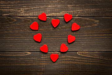 Valentine's day background. Red hearts placed in heart shape on the wooden desk