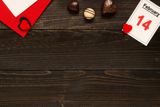 Valentine's day background with copy space. Valentine's Day card with chocolate on the wooden table.