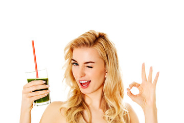 Young woman drinking green cocktail