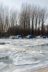 Frozen river with forest and boat