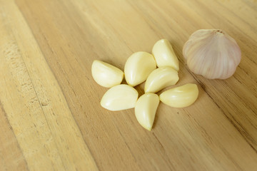 garlic bulb and piece of garlic on wood cutting board prepare cooking