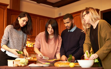 Group of multi ethnic young friends in kitchen prepare for party