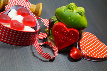 Valentine's concept. A box of heart-shaped candy in the shape of hearts and frog with big red heart