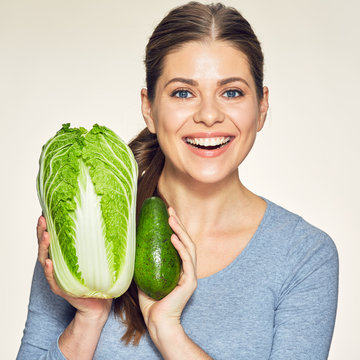 Beautiful young woman studio portrait with cabbage and avocado.