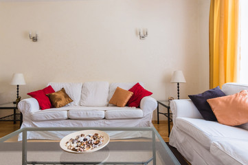 two white sofas with a coffee table in the living room