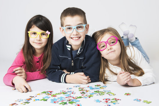 Happy kids playing with puzzle