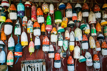 colored fishing floats on wooden wall - obrazy, fototapety, plakaty