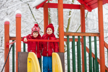 Sweet children, playing in the snow on the playground