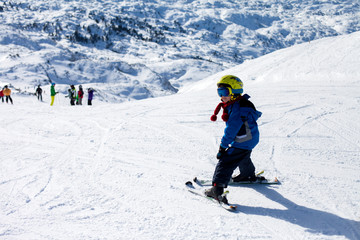 Fototapeta na wymiar Two young children, siblings brothers, skiing in Austrian mounta