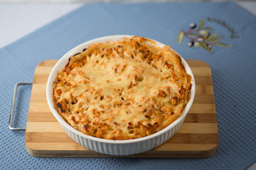 Lasagna with greens on a plate on a blue napkin, macaroni with chicken forcemeat