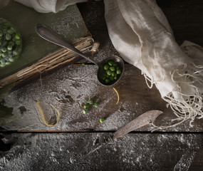 rustic still life, vintage. green peas, old books, flour on a wooden table. top view