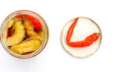 Glass jar of preserved red and green chilli isolated on white background
