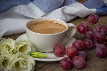 Still life with cup of coffee and flowers Eustoma and red grapes