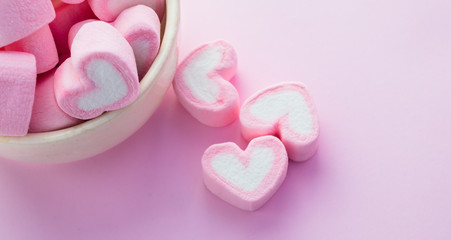 Pink heart-shaped marshmallows in with pink background