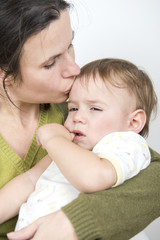 Mother kissing her Sad ill baby