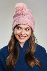 smiling young woman wearing warm winter scarf looking side.