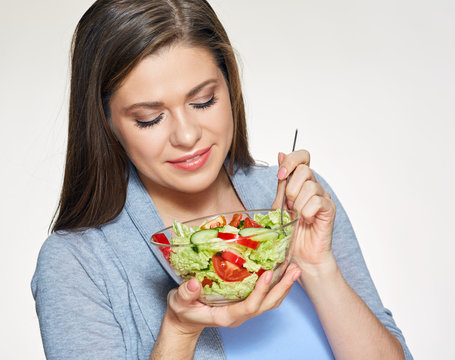 Smiling woman holding salad dish.