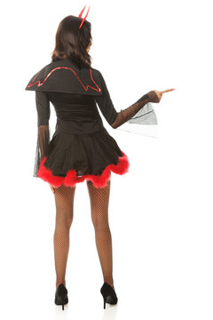Back view of woman pointing right wearing devil clothes