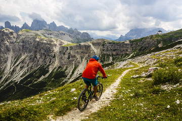 Fototapeta na wymiar View of cyclist riding mountain bike on trail in Dolomites,Tre C