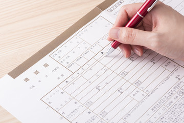 婚姻届に記入する女性の手