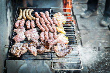 Mixed variety of Meat on barbecue grill with coal.