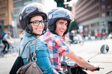 Lächelndes Mädchen mit Brille auf dem Sozius Sitz eines Motorrollers 