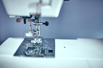 Seamstress inserts thread in old sewing machine