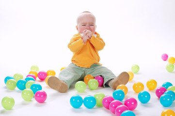 Fototapeta na wymiar cute crying girl with many colorful balls