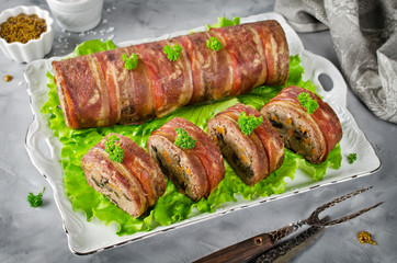 Oven baked meatloaf with bacon on a concrete grey background