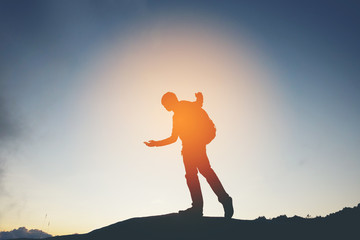 Silhouette Freedom man standing with raised arms and enjoying on