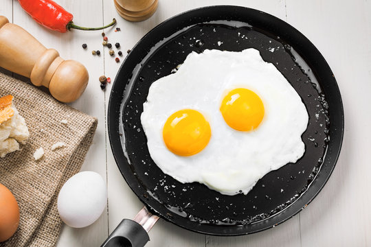 Delicious healthy simple breakfast meal made of eggs on a frying pan ready. Traditional homemade quick breakfast. International cuisine food. Top view.