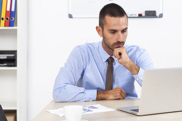 Stressed businessman working at his desk in his office