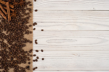 Coffee beans with cinnamon and star anise on an old wooden table