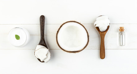 Homemade coconut products on white wooden table background. Oil,