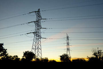 Fototapeta premium Towers supporting power lines in the twilight