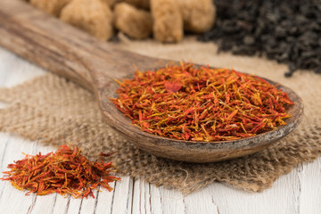 Fototapeta premium Saffron in a wooden spoon and an old white wooden table.