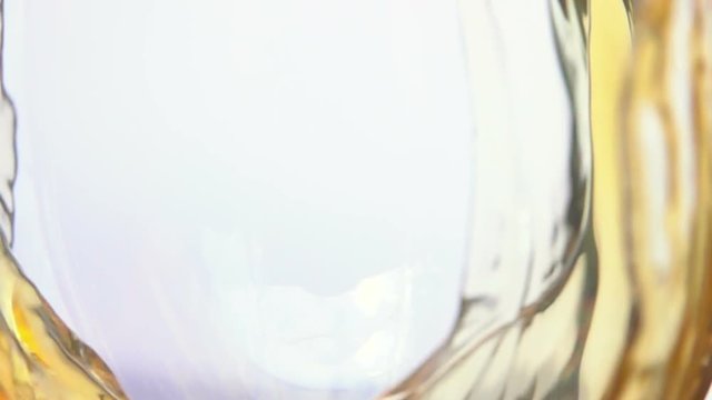 Wave of white wine curls in a glass