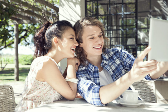 Young couple taking selfie with digital tablet