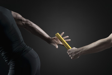 Runners passing baton, cropped
