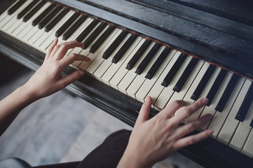The girl plays piano, close up , white and black keyboard