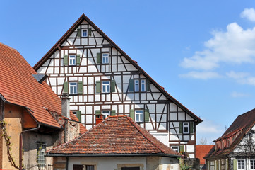 Facade of the old multistory half-timbered building. White wall with brown frame and windows with shutters. Bietigheim, Baden-Wurttemberg, Germany.