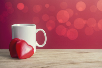 Fototapeta na wymiar white coffee mug and two red heart