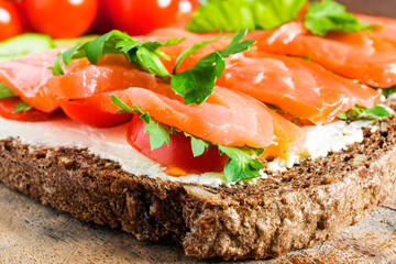 sandwich with salmon, cheese, tomatoes and herbs